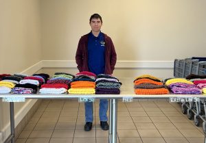 Elder Hallcok entrega de gorros y bufandas tejidos a mano, en Utah. Créditos: La Iglesia de Jesucristo de los Santos de los Últimos Días